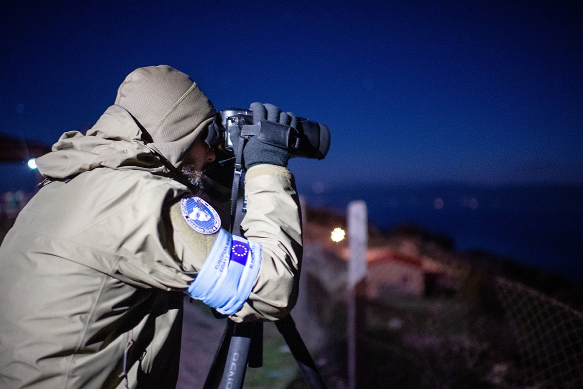 Person in Frontexuniform mit Fernglas