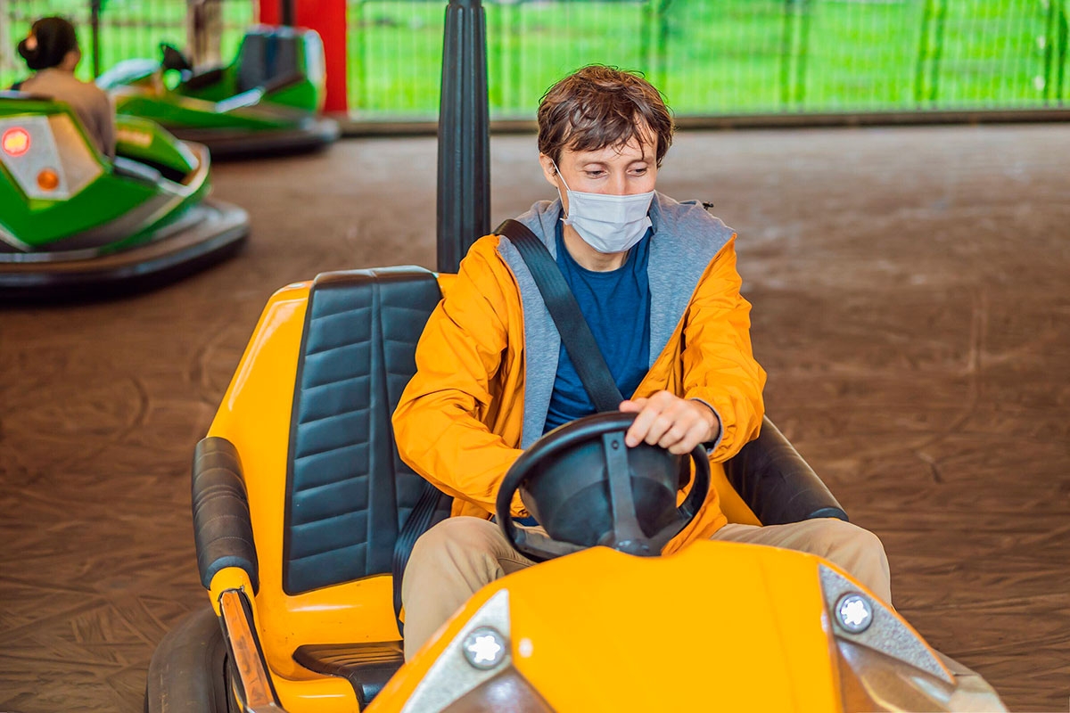 Person mit Maske im Autoscooter