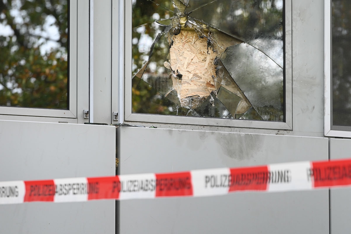 Ein zerschlagenes Fenster hinter Absperrband