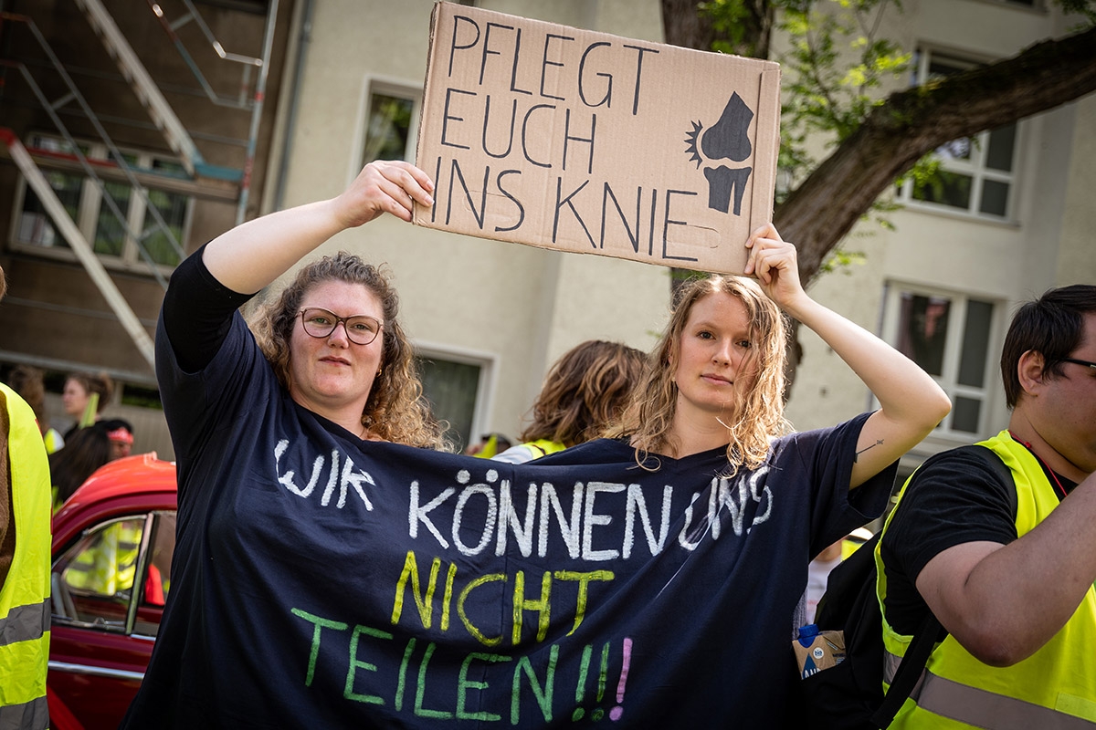 Zwei Demostrierende tragen ein großes T-Shirt mit der Aufschrift "Wir können uns nicht teilen!"