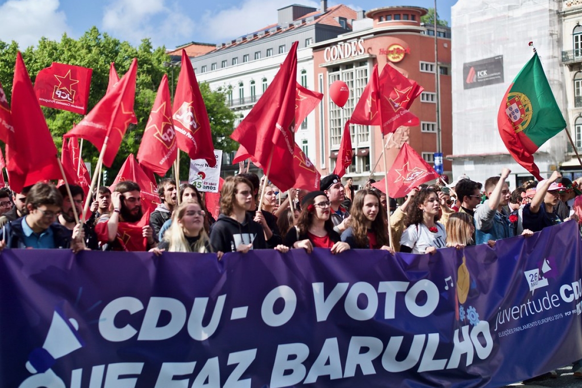 Rote Fahnen und ein Transparent auf einer Demostration 