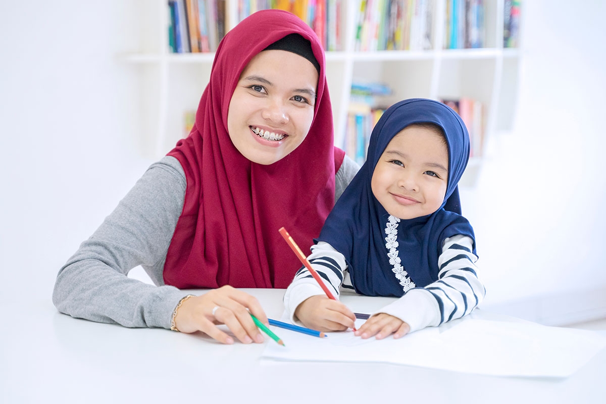 Sehr junge Mutter und mit kleiner Tochter, beide mit Hijab