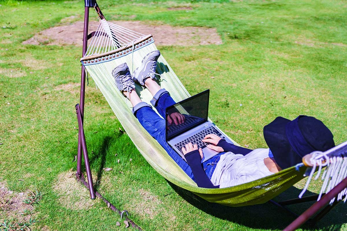 Mensch mit Laptop in Hängematte