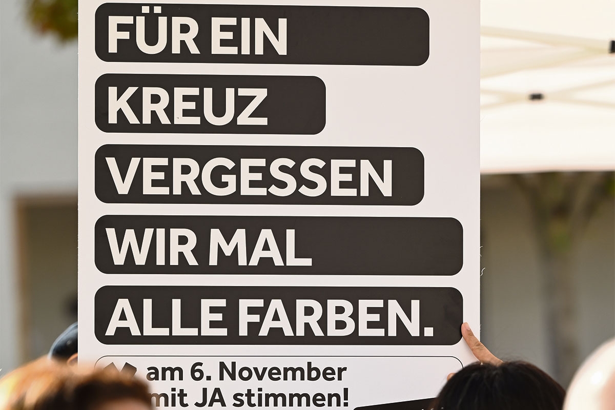 Ein Plakat mit der Aufschrift "Für ein Kreuz vergessen wir mal alle Farben"