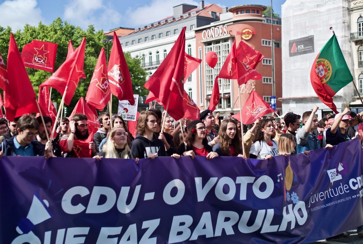 Rote Fahnen und ein Transparent auf einer Demostration 