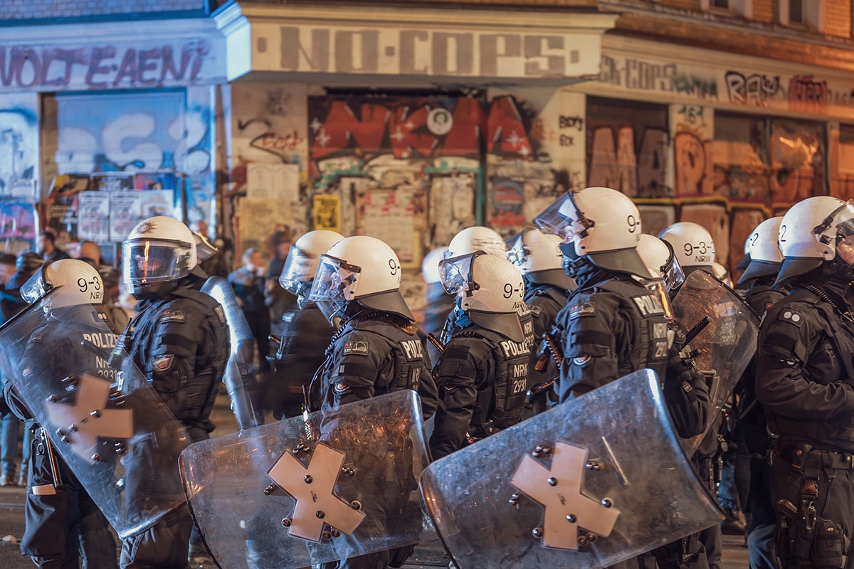 Polizist:innen vor "No Cops"- Schriftzug in Leipzig