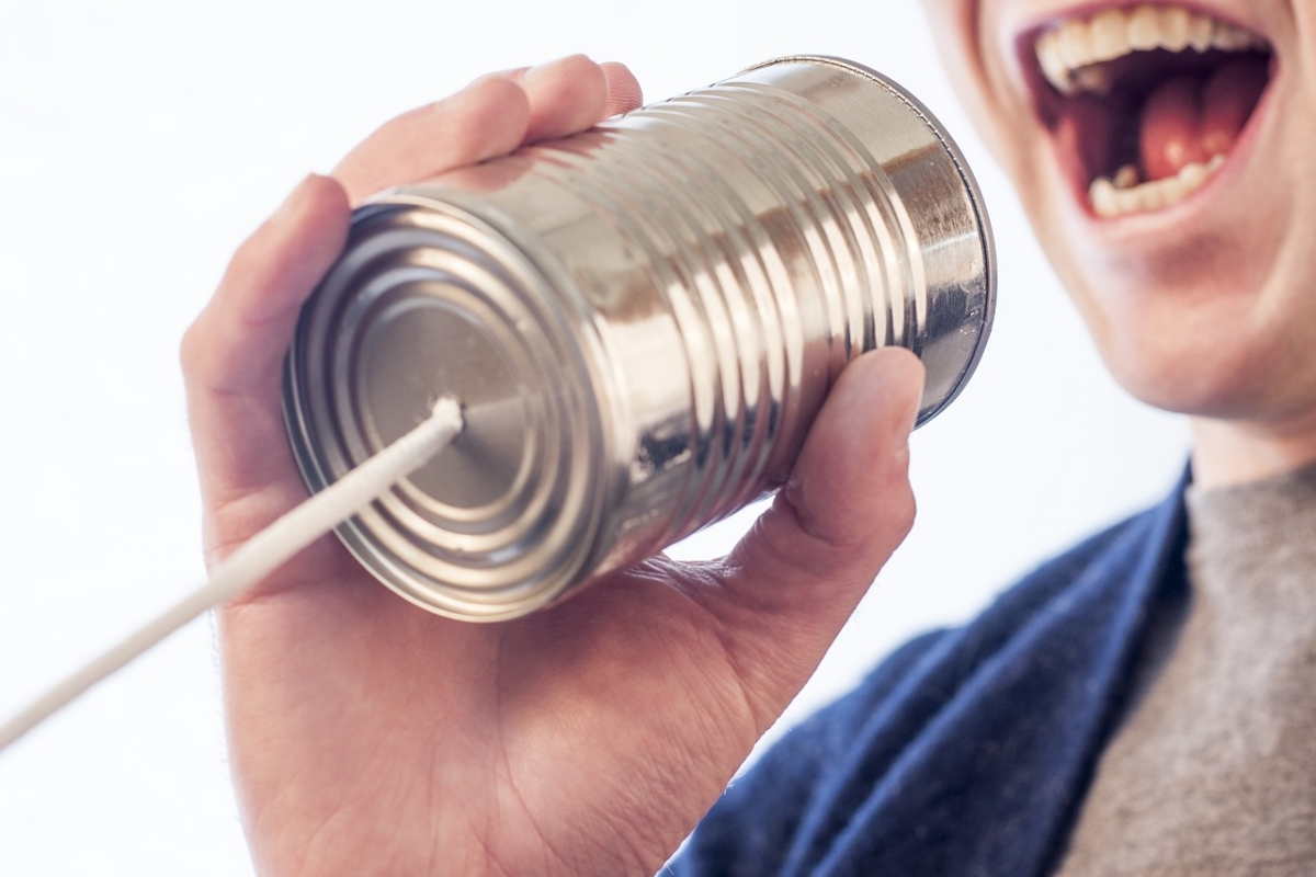 Mann spricht in Dosentelefon