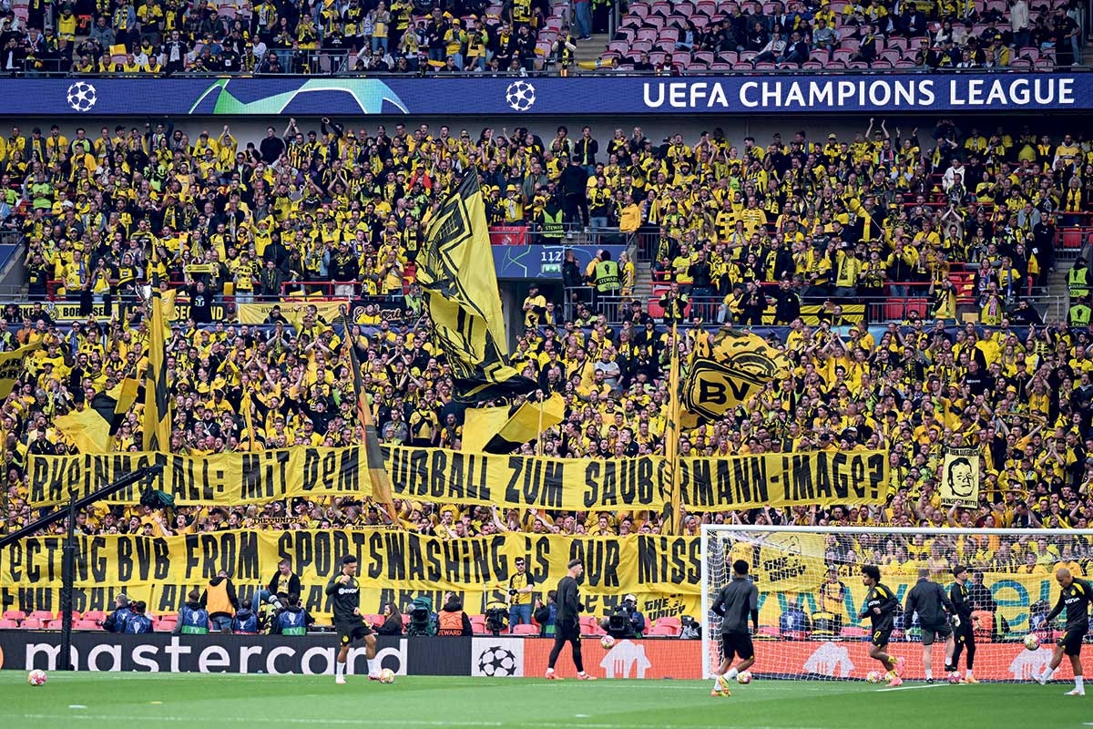 Dortmund-Fans mit einem Spruchband "Rheinmetall: Mit dem Fußball zum Saubermann-Image?"