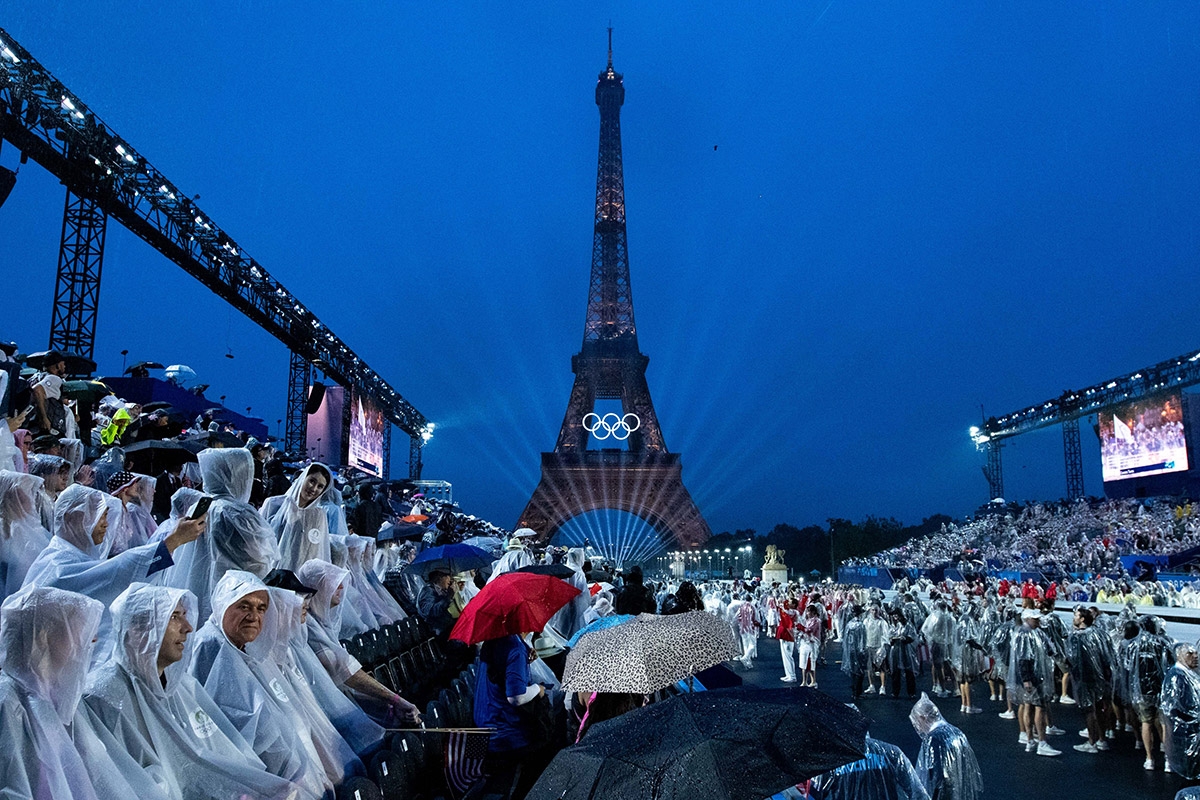 Lassen sich das Spektakel trotz Regen nicht entgehen: Zuschauer am Pariser Trocadero bei der Eröffnungsfeier der Olympischen Sommerspiele