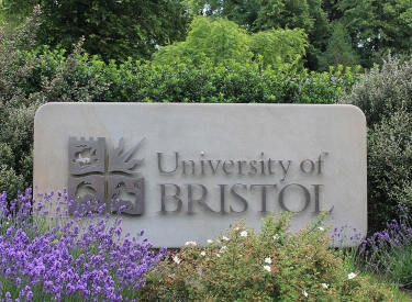 Stein mit Logo der University of Bristol umgeben von Pflanzen