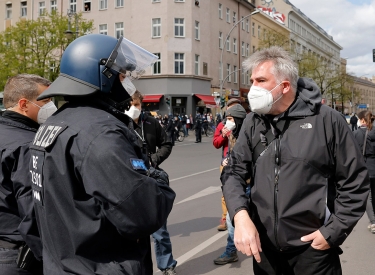 Jörg Reichel bittet bei einer Demonstration in Kreuzberg im April 2021 den Polizeiführer, mäßigend auf das aggressive Verhalten der Beamten gegen die Presse einzuwirken