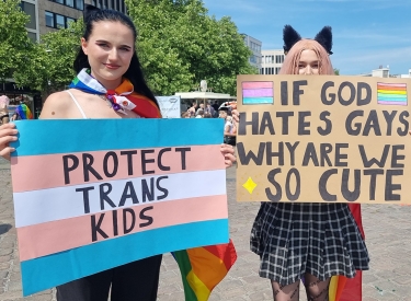 "Protect Trans Kids" und "If God hates Gays why we are so cute?" - zwei Schilder auf einer Parade in Hannover