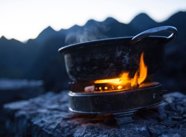 Gaskocher mit Bergkette im Hintergrund