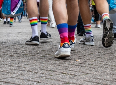 Aufnahme von mehreren Füßen in verschiedenen Regenbogensocken