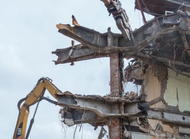 Bagger reißen ein Haus ab