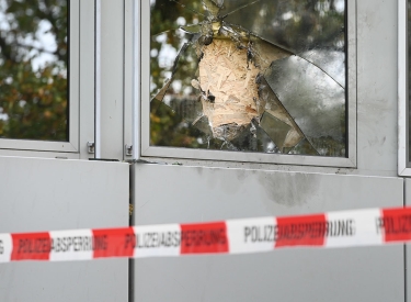 Ein zerschlagenes Fenster hinter Absperrband