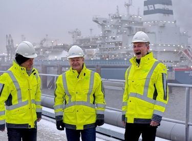 Robert Habeck, Olaf Scholz und Christian Lindner in neongelben Jacken und mit Baustellenhelmen