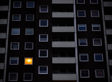 Hochhaus mit nur einem beleuchteten Fenster