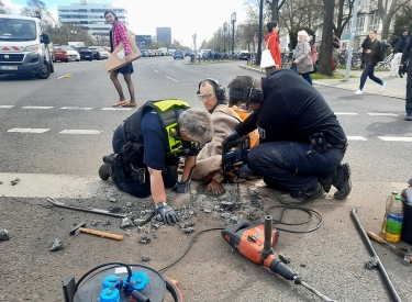 Polizisten lösen die Hand eines Aktivisten der Letzten Generation