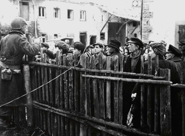 Ein US-Soldat belehrt nach der Besetzung eines deutschen Dorfes Anfang 1945 die Einwohner über die Vorschriften für die Zivilbevölkerung