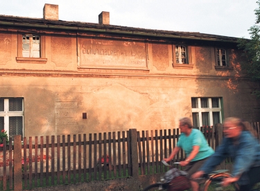 Verblichene deutsche Inschrift einer Schuhmacherwerkstatt an einer Hauswand aus der Zeit vor 1945 im oberschlesischen Jemielnica in Polen, aufgenommen am 2. August 1996