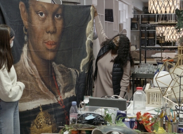 Vom Glück des Findens. Cleo (Thelma Buabeng, Mitte) entdeckt das Porträt »African Woman Holding a Clock« als Aufdruck auf einem Duschvorhang