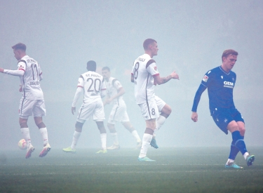 Nach einer Pyro-Aktion von Fans des Karlsruhe SC im November 2022 wärmen sich die Mannschaften auf