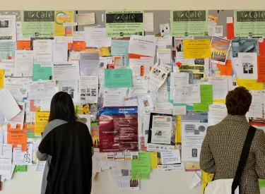 Eine Studentin der Freien Universität Berlin studiert das Schwarze Brett