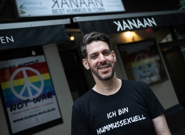 Inhaber Oz Ben David Ende Juli vor dem Restaurant »Kanaan« in Berlin. Er trägt ein T-Shirt mit der Aufschrift "Ich bin hummussexuell".