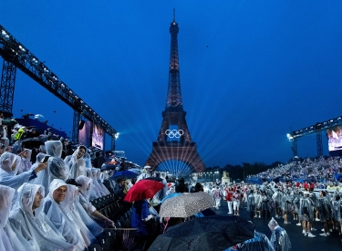 Lassen sich das Spektakel trotz Regen nicht entgehen: Zuschauer am Pariser Trocadero bei der Eröffnungsfeier der Olympischen Sommerspiele